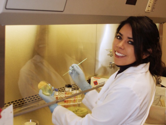 student smiling with a petri dish